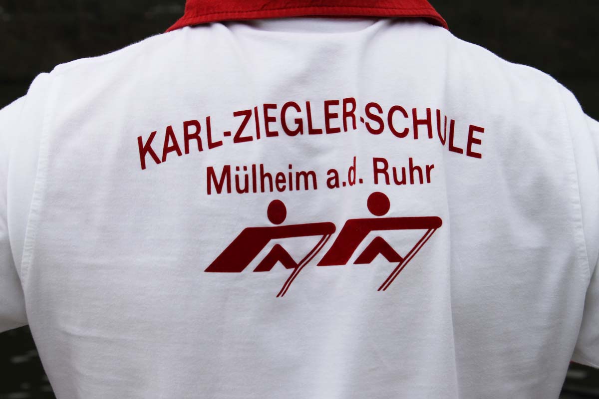 Weißes T-Shirt mit roter Aufschrift „KARL-ZIEGLER-SCHULE Mülheim a.d. Ruhr“ und Ruderlogo.